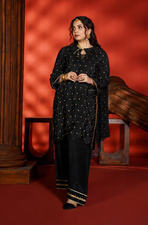 Woman in a black traditional outfit with gold details against a red background